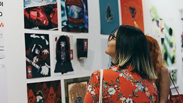 Students looking at art and design pictures in studio