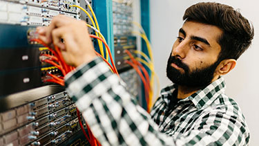 Student working with cables and computer servers