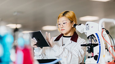 Female student wearing lab coat in a lab