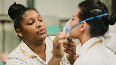 Nursing students using oxygen mask