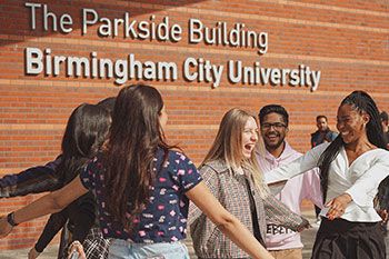 Students greeting eachother and happy outside university building