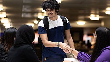 Male student welcomed by other students