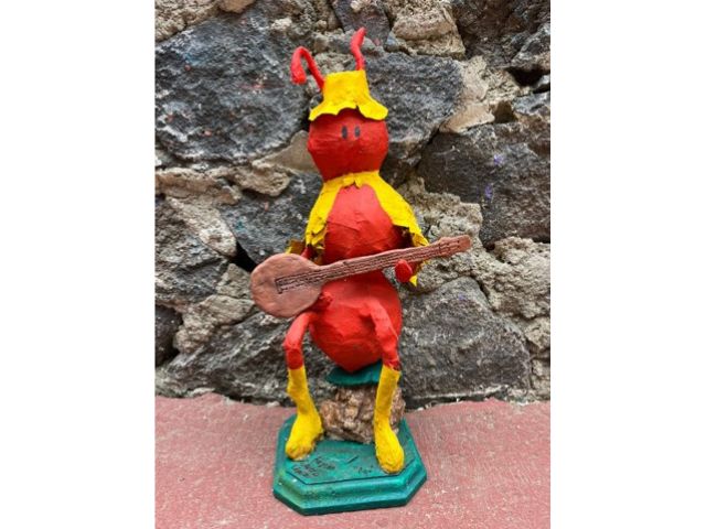 Clay model of red ant playing guitar