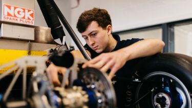 Student examining engine