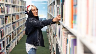 Student choosing book from shelf